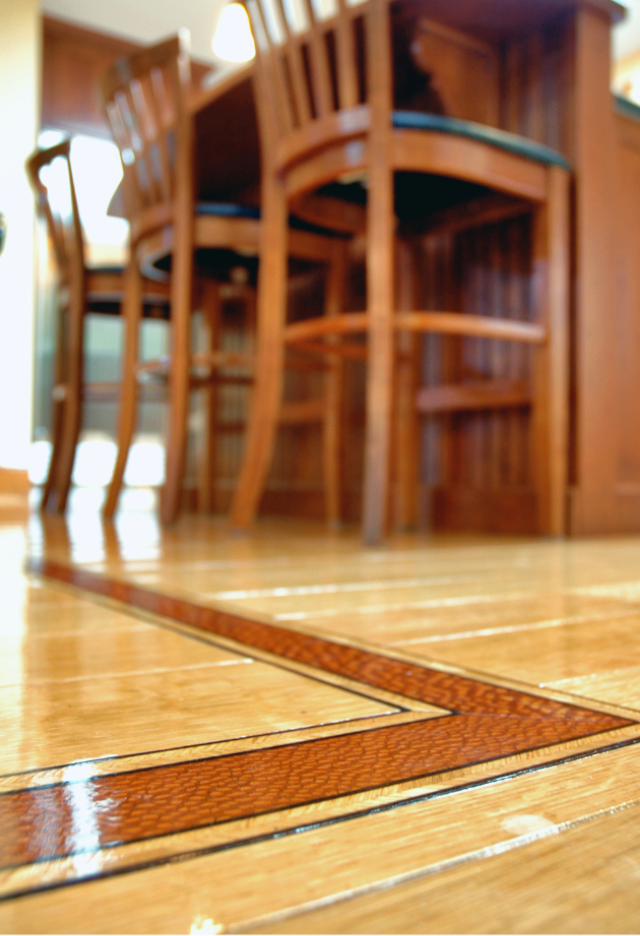 Neo Deco hardwood flooring with a geometric inlay border beneath a wooden dining table and chairs